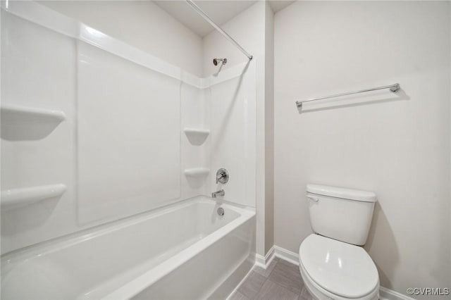 bathroom with tile patterned flooring, shower / bathing tub combination, and toilet