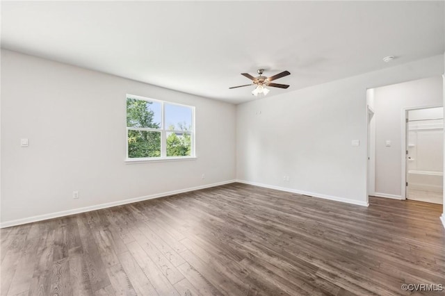 unfurnished room with ceiling fan and dark wood-type flooring