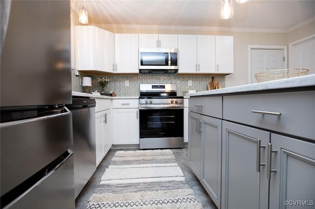 kitchen featuring gray cabinetry, stainless steel appliances, decorative backsplash, white cabinets, and ornamental molding