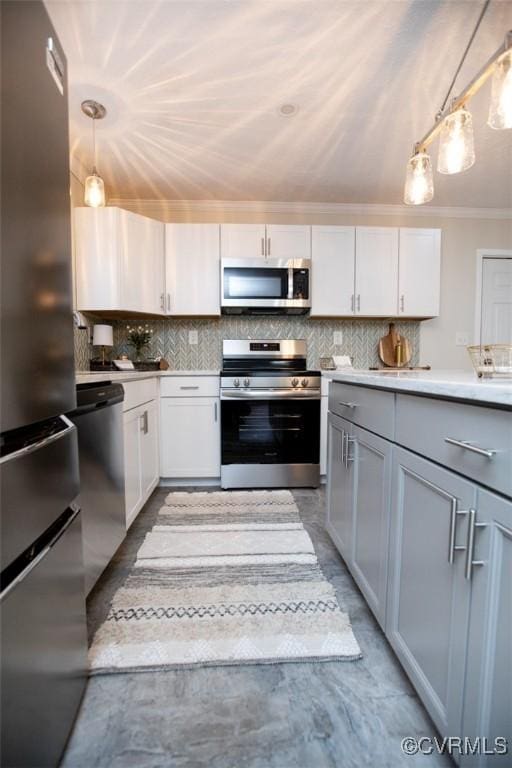 kitchen with crown molding, white cabinetry, hanging light fixtures, and stainless steel appliances