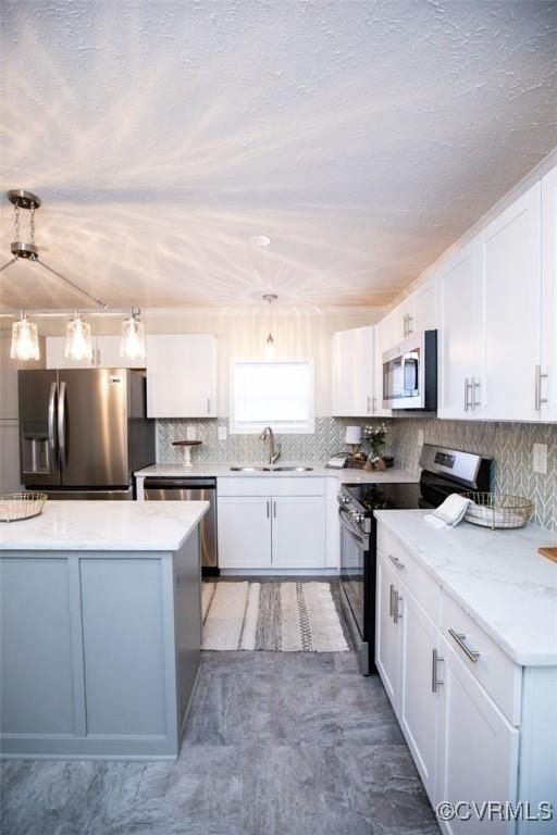 kitchen featuring white cabinets, sink, hanging light fixtures, light stone counters, and stainless steel appliances