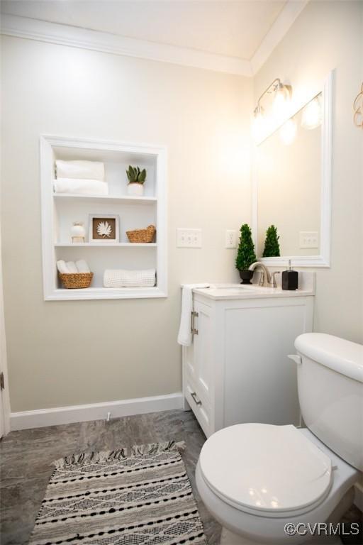 bathroom with vanity, ornamental molding, and toilet