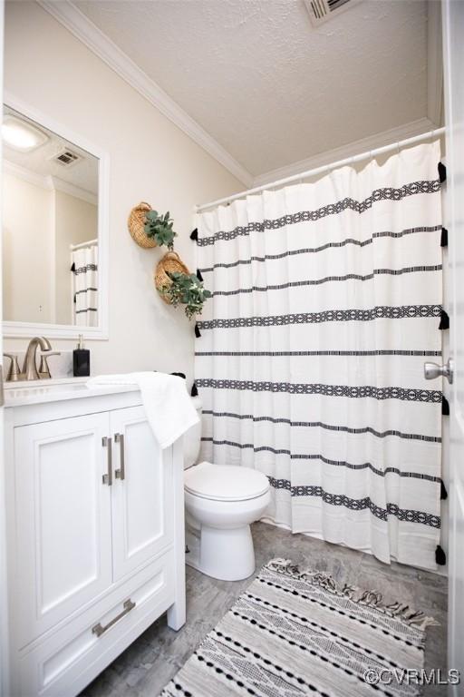 bathroom with vanity, hardwood / wood-style flooring, toilet, ornamental molding, and a textured ceiling