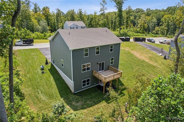 rear view of house with a lawn and a wooden deck