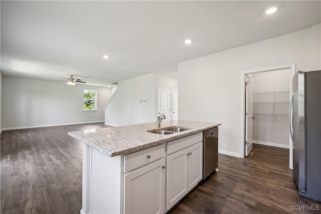 kitchen featuring white cabinets, dark hardwood / wood-style floors, light stone countertops, an island with sink, and stainless steel appliances