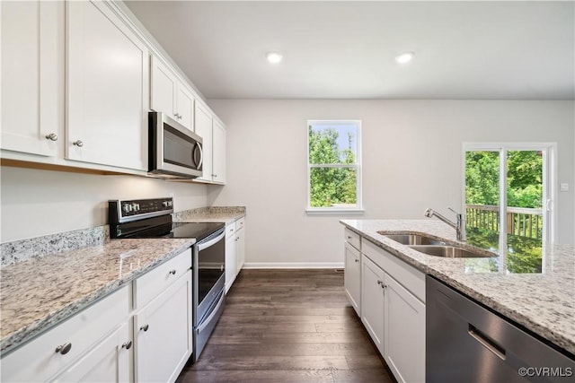 kitchen featuring dark hardwood / wood-style flooring, a wealth of natural light, stainless steel appliances, sink, and white cabinets