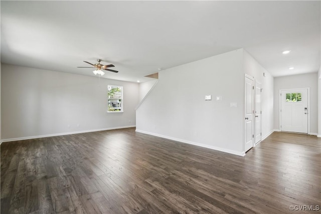 empty room featuring a wealth of natural light, dark hardwood / wood-style flooring, and ceiling fan