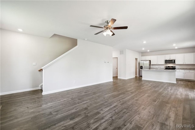 unfurnished living room with ceiling fan and dark hardwood / wood-style flooring