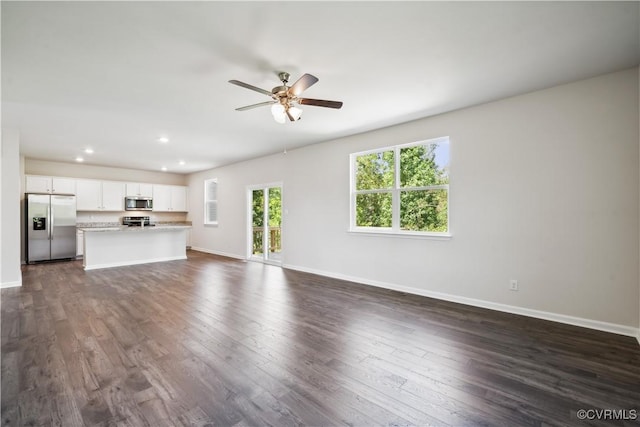 unfurnished living room featuring dark hardwood / wood-style floors and ceiling fan