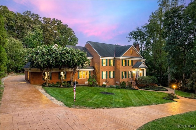 view of front facade featuring brick siding and a yard