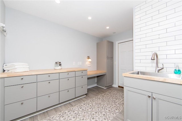 full bath featuring recessed lighting, a sink, and wood finish floors