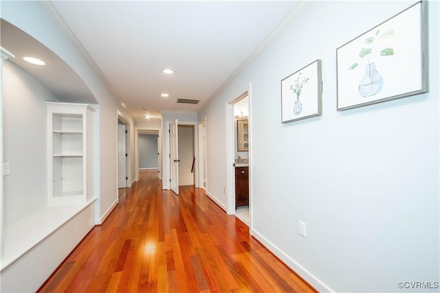 hallway featuring ornamental molding, recessed lighting, visible vents, and wood finished floors