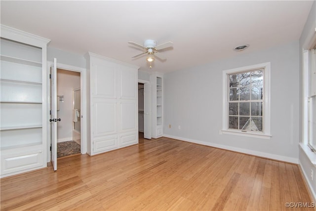 unfurnished bedroom featuring light wood finished floors, a ceiling fan, visible vents, and baseboards