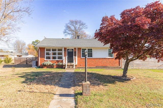 view of front of home with cooling unit and a front lawn