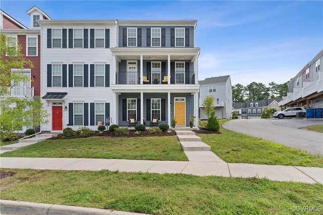 view of front of house featuring a balcony and a front yard