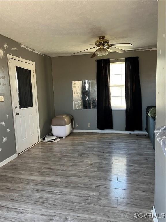 empty room featuring hardwood / wood-style flooring, ceiling fan, and a textured ceiling