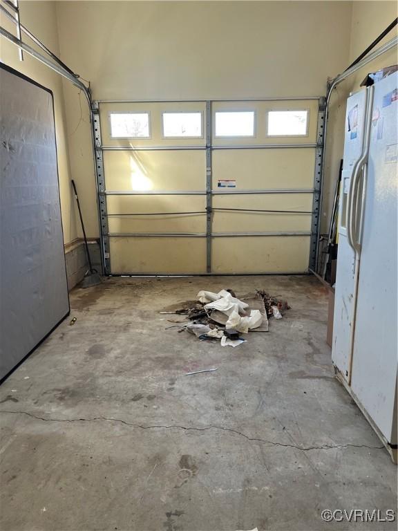 garage featuring white fridge with ice dispenser