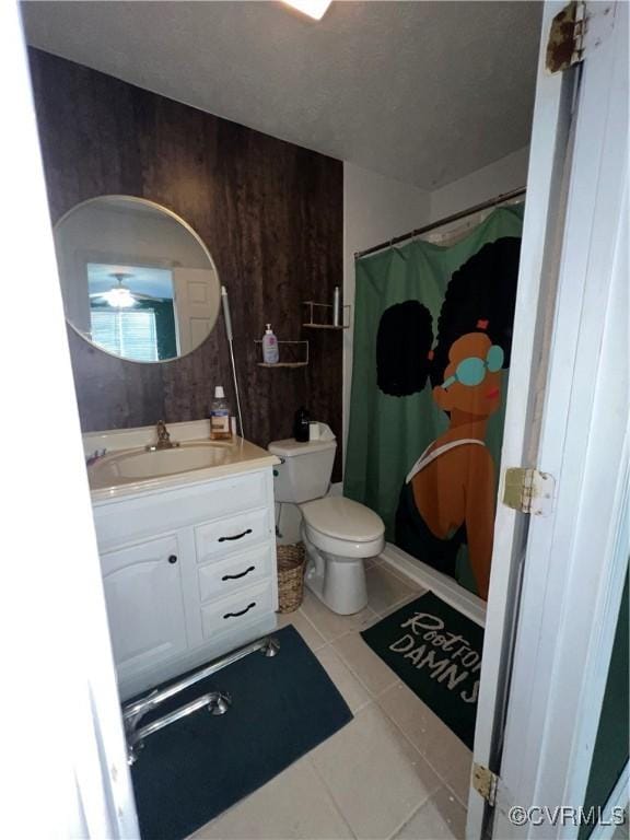 bathroom featuring walk in shower, tile patterned floors, wood walls, toilet, and vanity