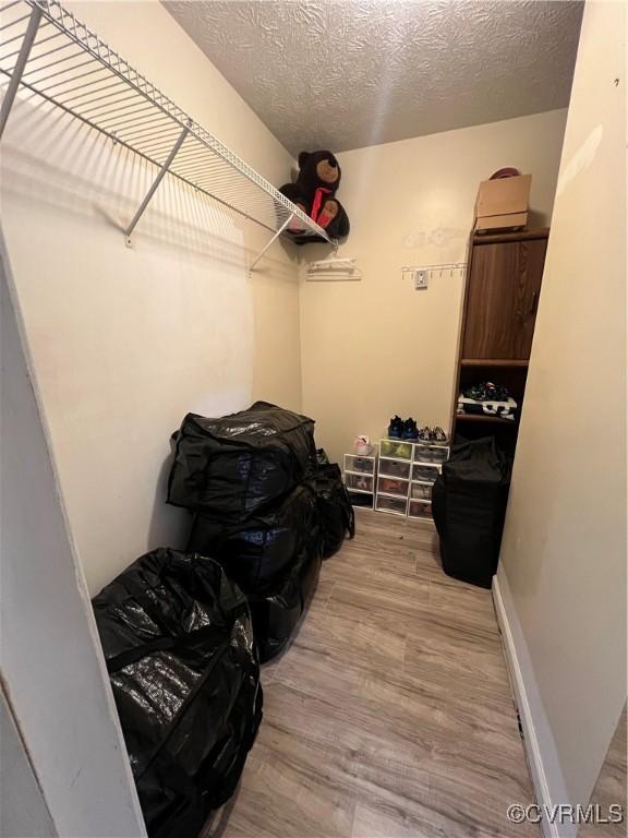 laundry area with a textured ceiling and hardwood / wood-style flooring