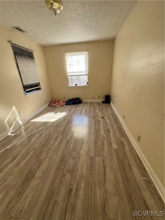 spare room featuring a textured ceiling and hardwood / wood-style flooring