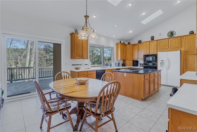 kitchen featuring a skylight, a center island, a notable chandelier, pendant lighting, and black appliances