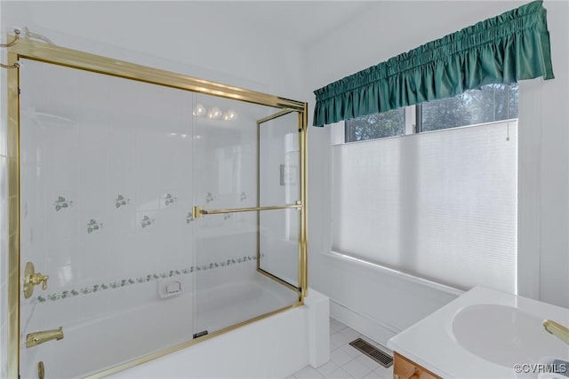 bathroom with tile patterned flooring, vanity, and bath / shower combo with glass door