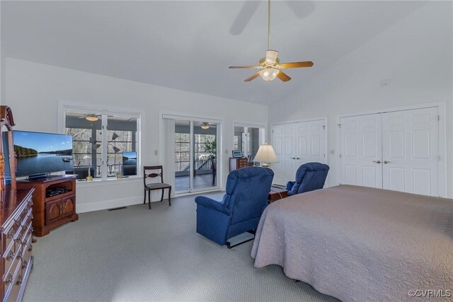 carpeted bedroom with ceiling fan, access to exterior, high vaulted ceiling, and two closets