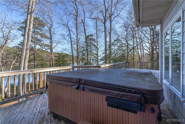 deck with a water view and a hot tub