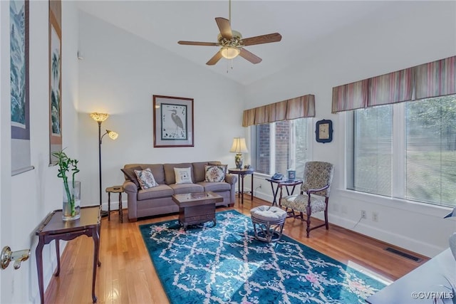 living room with ceiling fan, hardwood / wood-style floors, a healthy amount of sunlight, and lofted ceiling