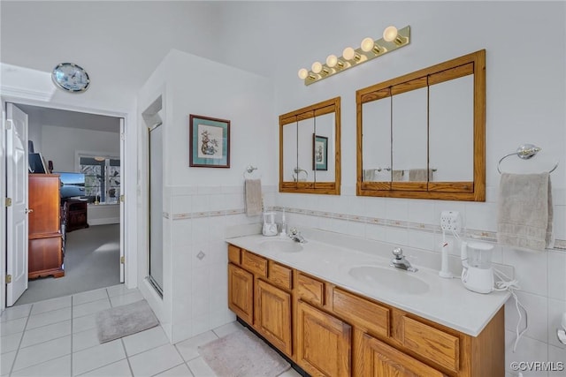 bathroom with tile patterned flooring, vanity, tile walls, and a shower with shower door