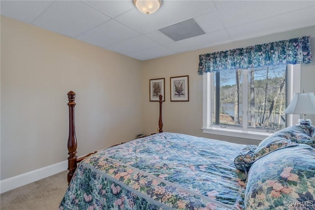 bedroom featuring a drop ceiling and carpet floors