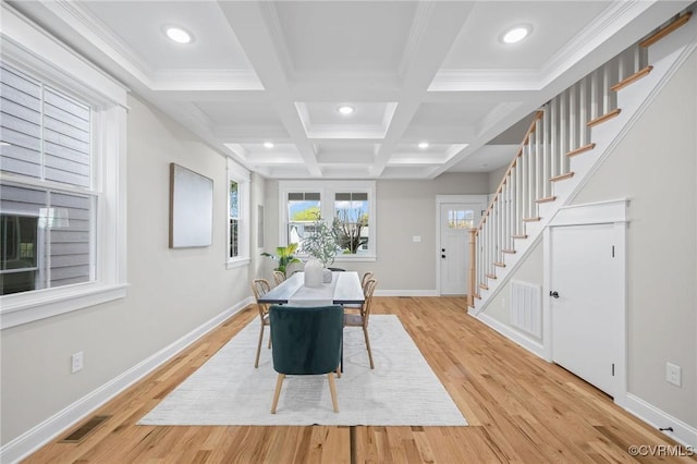 dining area with coffered ceiling, light hardwood / wood-style flooring, ornamental molding, and beamed ceiling