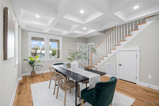 dining area featuring coffered ceiling, beam ceiling, ornamental molding, and hardwood / wood-style flooring