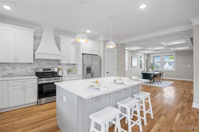 kitchen featuring white cabinetry, stainless steel appliances, a breakfast bar area, and custom exhaust hood