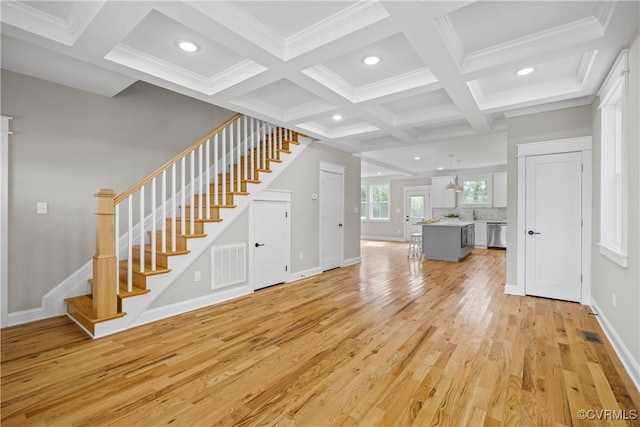 unfurnished living room with coffered ceiling, light hardwood / wood-style flooring, ornamental molding, and beamed ceiling