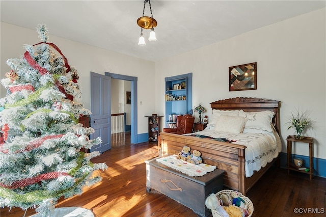 bedroom with dark hardwood / wood-style flooring