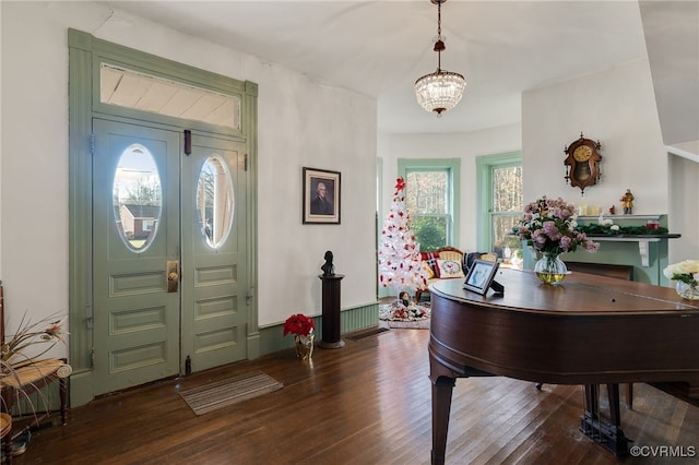 entryway featuring dark wood-type flooring and a notable chandelier