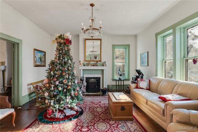 living room with hardwood / wood-style floors, crown molding, a healthy amount of sunlight, and a notable chandelier