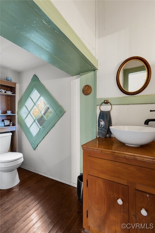 bathroom with hardwood / wood-style floors, vanity, and toilet