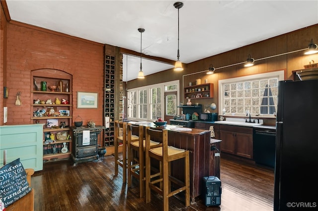 kitchen with black appliances, sink, hanging light fixtures, dark hardwood / wood-style floors, and a breakfast bar area