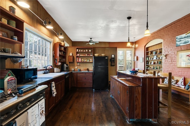 kitchen featuring black appliances, a healthy amount of sunlight, a breakfast bar area, and pendant lighting