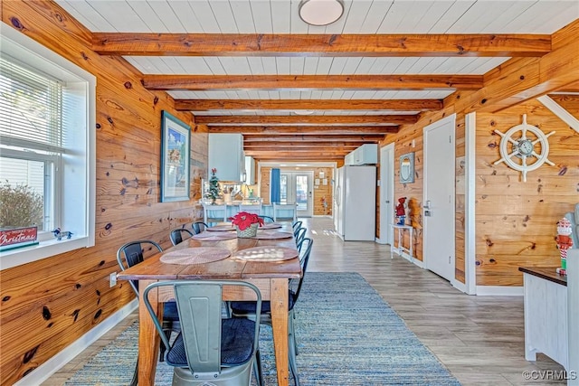 dining space with plenty of natural light and wooden walls