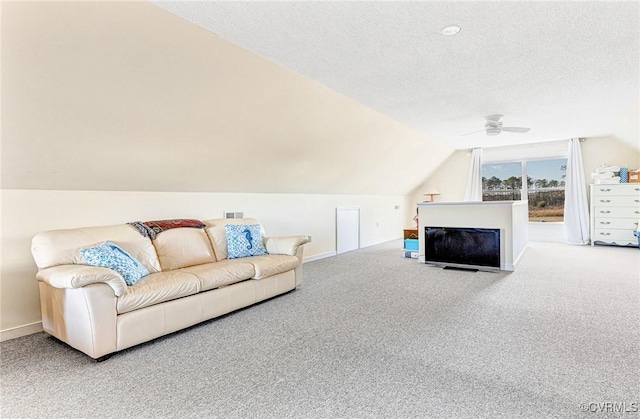 living room featuring a textured ceiling, carpet floors, vaulted ceiling, and ceiling fan