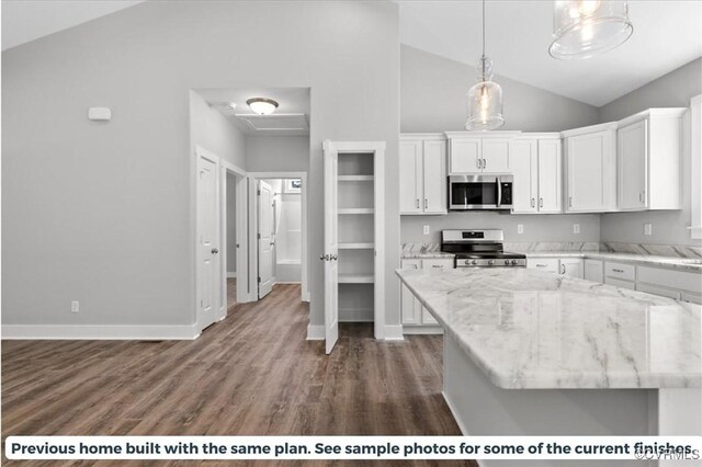 kitchen with stainless steel appliances, white cabinets, pendant lighting, and light stone countertops