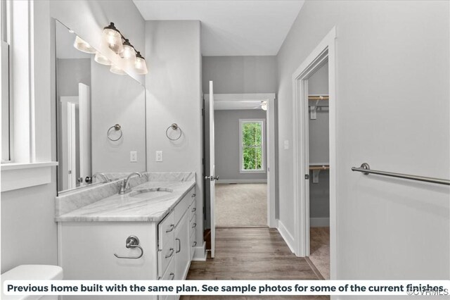 bathroom featuring hardwood / wood-style floors, toilet, ceiling fan, and vanity