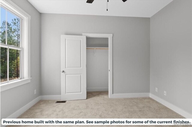 unfurnished bedroom with light colored carpet, ceiling fan, a closet, and multiple windows