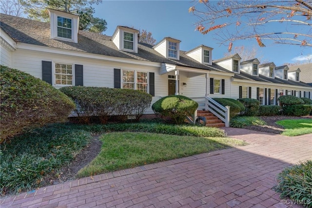 new england style home featuring a front lawn