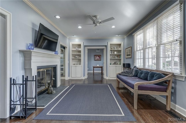 recreation room with dark hardwood / wood-style flooring, built in features, ceiling fan, and crown molding