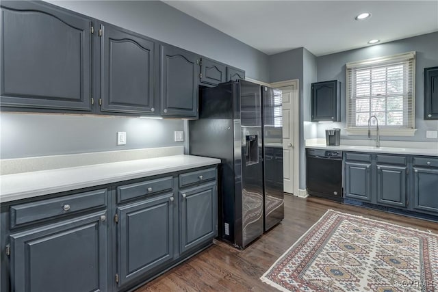 kitchen with sink, dark hardwood / wood-style floors, and black appliances