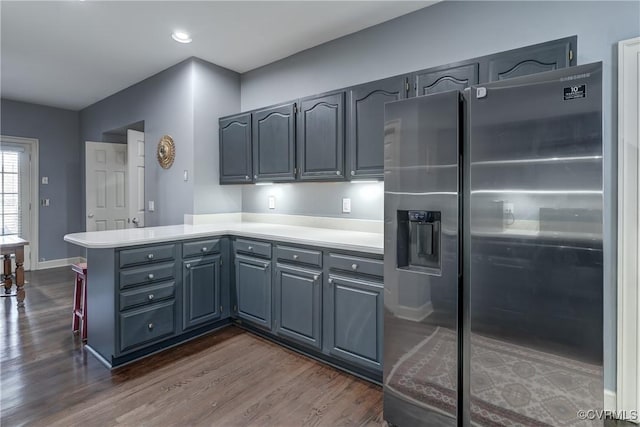 kitchen featuring kitchen peninsula, high end refrigerator, dark wood-type flooring, and gray cabinetry